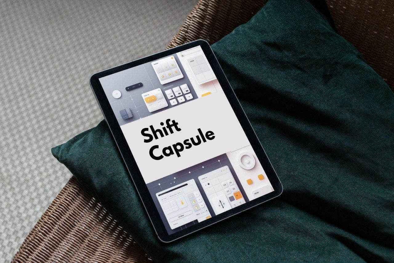 A tablet device lying on a dark green cushion over a woven chair, displaying the Shift Capsule interface on its screen.